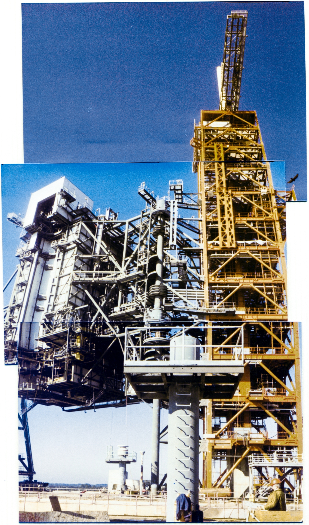 Image 045. Viewed from “ground level”, fifty feet above the surrounding wilderness of the Merritt Island Wildlife Refuge on the Pad Deck at Space Shuttle Launch Complex 39-B, Kennedy Space Center, Florida, the great towers of the Rotating Service Structure and Fixed Service Structure loom into the sky far above you. When swung around into the “Mate” position, the extreme far end of the RSS held up by the heavy iron of Column Line 7, a portion of which is visible above the Pad Deck to the far left, will wind up directly in front of you, just a couple of meters away, spanning the Flame Trench, a bit of which is visible along the bottom margin of the image. Photo by James MacLaren.